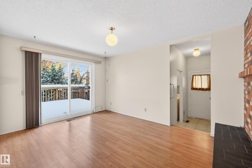 Empty room featuring a textured ceiling, plenty of natural light, and light wood finished floors - 3626 103B Street, Edmonton, AB - Indoor