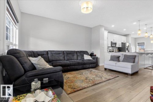 Living area featuring light wood flooring, a window providing natural light, and a ceiling light fixture - 203 Cavanagh Common, Edmonton, AB - Indoor Photo Showing Living Room