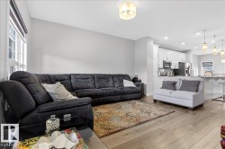 Living area featuring light wood flooring, a window providing natural light, and a ceiling light fixture - 