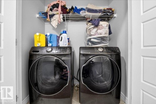 This laundry area features a white wire shelf, with a light gray wall color, and white doors - 203 Cavanagh Common, Edmonton, AB - Indoor Photo Showing Laundry Room
