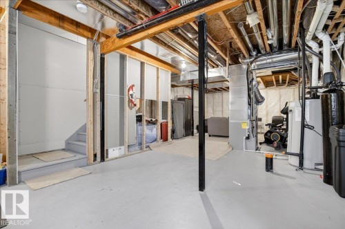 The property features a spacious, unfinished basement with a concrete floor and exposed wooden beams - 203 Cavanagh Common, Edmonton, AB - Indoor Photo Showing Basement