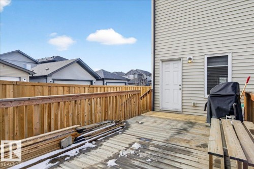 The property features a wooden deck with a privacy fence - 203 Cavanagh Common, Edmonton, AB - Outdoor With Deck Patio Veranda With Exterior