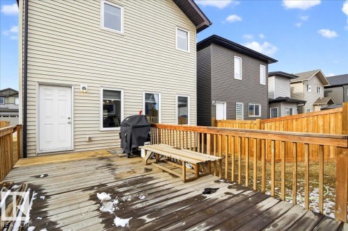 The property features a spacious rear deck with wooden railings, providing an outdoor living area - 203 Cavanagh Common, Edmonton, AB - Outdoor With Deck Patio Veranda With Exterior