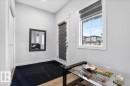 This entry area features light wood flooring, a window providing natural light, and a white door with a window blind - 203 Cavanagh Common, Edmonton, AB  - Indoor Photo Showing Other Room 