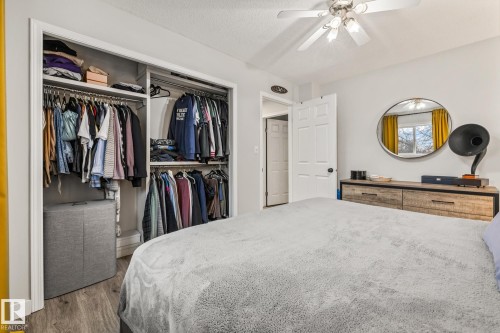 The bedroom features built-in closet storage, a ceiling fan with light, and hardwood flooring - 9321 92 Street, Edmonton, AB - Indoor