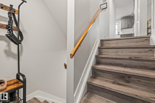 The property features a staircase with wood-look treads, a white banister, and a wooden handrail - 9321 92 Street, Edmonton, AB - Indoor Photo Showing Other Room
