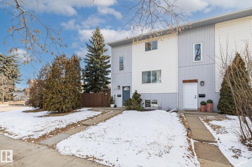The property features a multi-level facade with horizontal siding and a paved walkway leading to the entrance - 9321 92 Street, Edmonton, AB - Outdoor