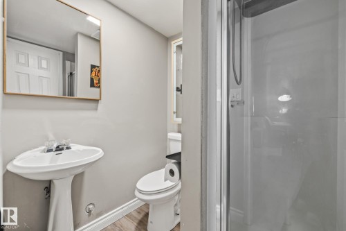The bathroom features a pedestal sink, a toilet, and a glass-enclosed shower - 9321 92 Street, Edmonton, AB - Indoor Photo Showing Bathroom