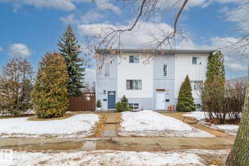 The property features a two-story exterior with light-colored siding and a contrasting darker lower level - 9321 92 Street, Edmonton, AB - Outdoor