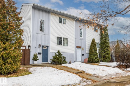 The property features a two-story exterior with light-colored siding, a visible address number, and a blue entrance door - 9321 92 Street, Edmonton, AB - Outdoor
