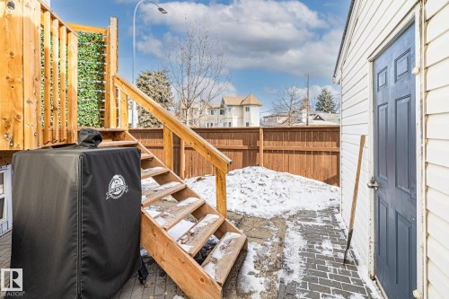 The property features a wooden deck with stairs, a privacy fence, and a paved patio area - 9321 92 Street, Edmonton, AB - Outdoor With Deck Patio Veranda