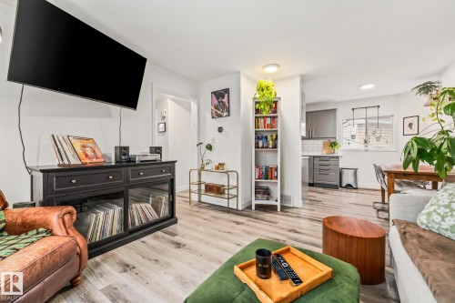 The living space features light-colored flooring, a white ceiling with recessed lighting, and a view into the kitchen and dining area - 9321 92 Street, Edmonton, AB - Indoor Photo Showing Living Room