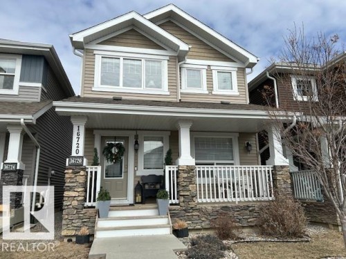 The property features a charming exterior with light brown siding and white trim - 16720 15 Avenue, Edmonton, AB - Outdoor With Deck Patio Veranda With Facade