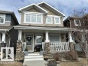 The property features a charming exterior with light brown siding and white trim - 16720 15 Avenue, Edmonton, AB  - Outdoor With Deck Patio Veranda With Facade 