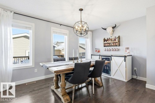 This dining area features hardwood floors and two windows providing natural light - 16720 15 Avenue, Edmonton, AB - Indoor Photo Showing Dining Room