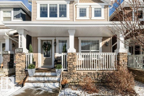 The property features a charming exterior with stone accents and a covered front porch - 16720 15 Avenue, Edmonton, AB - Outdoor With Deck Patio Veranda With Facade