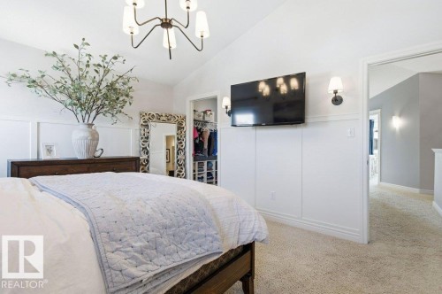 Bedroom featuring vaulted ceilings, board and batten wall detailing, and a closet with organizational shelving - 16720 15 Avenue, Edmonton, AB - Indoor Photo Showing Bedroom
