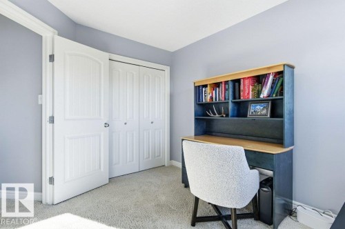 The room features light gray walls, a light gray carpet, a white door, and white bi-fold closet doors - 16720 15 Avenue, Edmonton, AB - Indoor Photo Showing Office