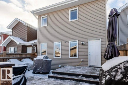 The property features a private deck area with wooden steps and a white exterior door - 16720 15 Avenue, Edmonton, AB - Outdoor With Deck Patio Veranda