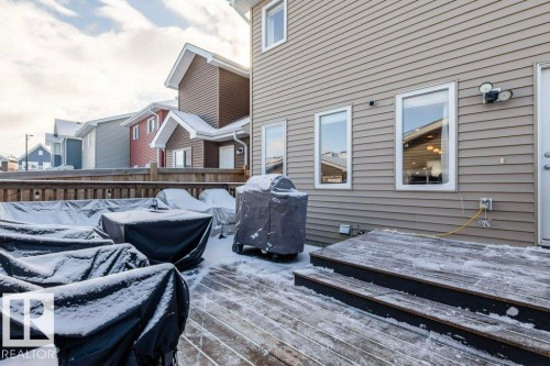 The property features a wooden deck with steps, an exterior door, and windows - 16720 15 Avenue, Edmonton, AB - Outdoor With Deck Patio Veranda