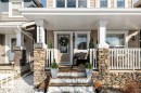 The property features a welcoming front porch with stone-clad columns, white railings, and a staircase leading to the entrance - 16720 15 Avenue, Edmonton, AB  - Outdoor With Deck Patio Veranda With Facade 