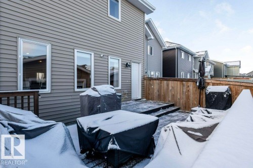 The property features a private deck with wooden railings, and a side door providing exterior access - 16720 15 Avenue, Edmonton, AB - Outdoor With Exterior