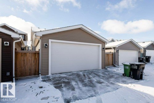 Detached garage with a white overhead door and an exterior light fixture - 16720 15 Avenue, Edmonton, AB - Outdoor With Exterior