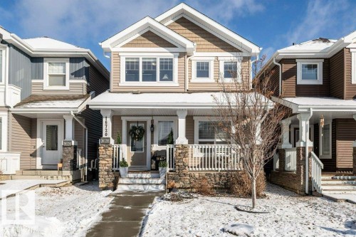 The property features a charming exterior with stone accents, a welcoming front porch, and a white railing - 16720 15 Avenue, Edmonton, AB - Outdoor With Deck Patio Veranda With Facade