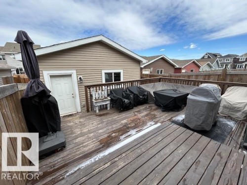 This property features a spacious wooden deck, complete with a wooden railing - 16720 15 Avenue, Edmonton, AB - Outdoor With Deck Patio Veranda With Exterior