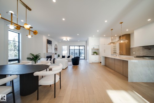 Spacious open-concept living area featuring light hardwood floors, recessed lighting, and large windows providing natural light - 13804 85 Avenue, Edmonton, AB - Indoor