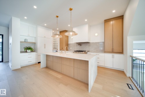 The kitchen features light-toned wood flooring, an island with a light-toned countertop, and recessed lighting - 13804 85 Avenue, Edmonton, AB - Indoor Photo Showing Kitchen With Upgraded Kitchen