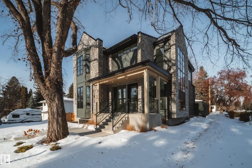 The property features a stone facade, a covered porch with pillars, and a prominent bay window - 13804 85 Avenue, Edmonton, AB - Outdoor