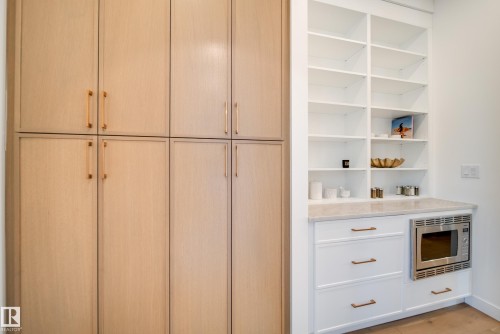 This space features extensive built-in storage with light wood cabinetry and white shelving - 13804 85 Avenue, Edmonton, AB - Indoor Photo Showing Other Room