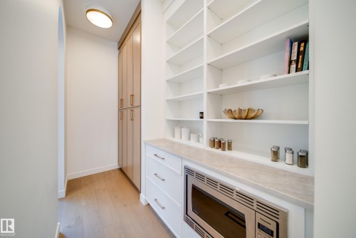 This room features built-in white shelving, a built-in microwave, white drawers, and a light-colored countertop - 13804 85 Avenue, Edmonton, AB - Indoor