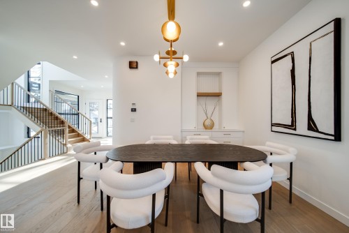 The dining area features light-toned flooring, recessed lighting, and a modern chandelier - 13804 85 Avenue, Edmonton, AB - Indoor Photo Showing Dining Room