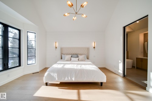 The property features a spacious room with hardwood floors, a vaulted ceiling, and large windows providing abundant natural light - 13804 85 Avenue, Edmonton, AB - Indoor Photo Showing Bedroom
