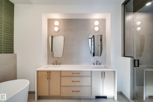 The bathroom features a dual vanity with light wood cabinetry, white countertops, and contemporary mirrors - 13804 85 Avenue, Edmonton, AB - Indoor Photo Showing Bathroom