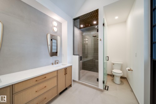 Bathroom featuring a double vanity with a light wood finish, a shower with a glass enclosure, and a toilet - 13804 85 Avenue, Edmonton, AB - Indoor Photo Showing Bathroom