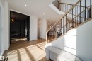 A bright and inviting entryway featuring hardwood floors, recessed lighting, and a contemporary staircase with black railings and a light wood banister - 13804 85 Avenue, Edmonton, AB  - Indoor Photo Showing Other Room 