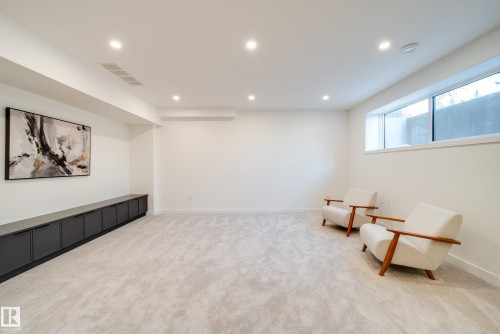 This spacious room features light-colored carpeting, recessed lighting, and a large window - 13804 85 Avenue, Edmonton, AB - Indoor