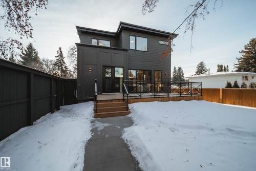 The property features a modern exterior with dark siding, a spacious deck with dark railings, and a concrete pathway leading to the entrance - 13804 85 Avenue, Edmonton, AB - Outdoor With Deck Patio Veranda