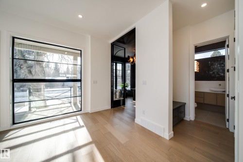 The property features hardwood floors, recessed lighting, and a large window with black framing - 13804 85 Avenue, Edmonton, AB - Indoor Photo Showing Other Room