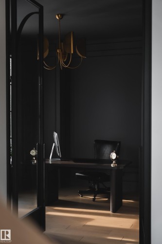 This room features dark wall paneling, light hardwood floors, and a brass chandelier - 13804 85 Avenue, Edmonton, AB - Indoor