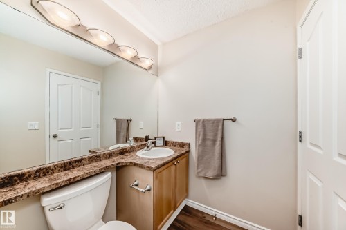 Half bathroom featuring vanity, a textured ceiling, and dark wood-style floors - 14 Spring Gate, Spruce Grove, AB - Indoor Photo Showing Bathroom