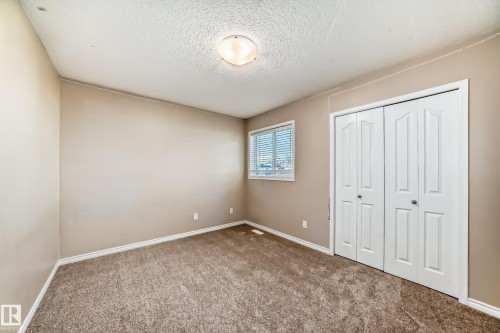 Unfurnished bedroom with carpet flooring, a closet, and a textured ceiling - 14 Spring Gate, Spruce Grove, AB - Indoor Photo Showing Other Room