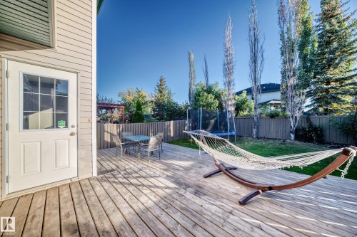 Wooden terrace with a trampoline, outdoor dining space, and a fenced backyard - 14 Spring Gate, Spruce Grove, AB - Outdoor With Deck Patio Veranda