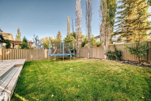 Fenced backyard featuring a trampoline and a deck - 14 Spring Gate, Spruce Grove, AB - Outdoor