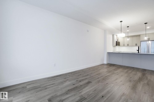 Open concept living space with wood-style flooring, white walls, and recessed lighting - 516 260 Bellerose Dr, St. Albert, AB - Indoor Photo Showing Kitchen