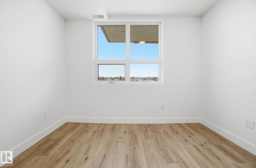 Room featuring light wood-style flooring and a window providing natural light and views of the surrounding area - 516 260 Bellerose Dr, St. Albert, AB - Indoor Photo Showing Other Room
