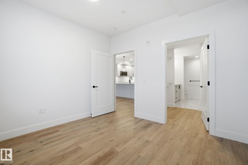 The living area features light-toned hardwood flooring and crisp white walls - 516 260 Bellerose Dr, St. Albert, AB - Indoor Photo Showing Other Room